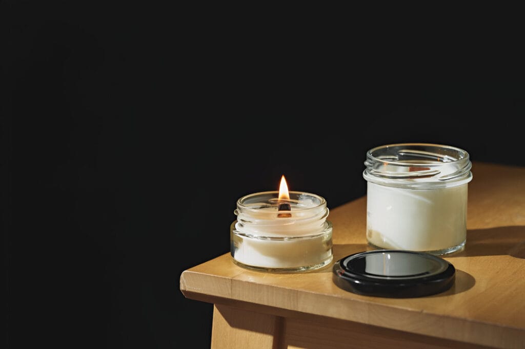 Two scented candles with one lighted