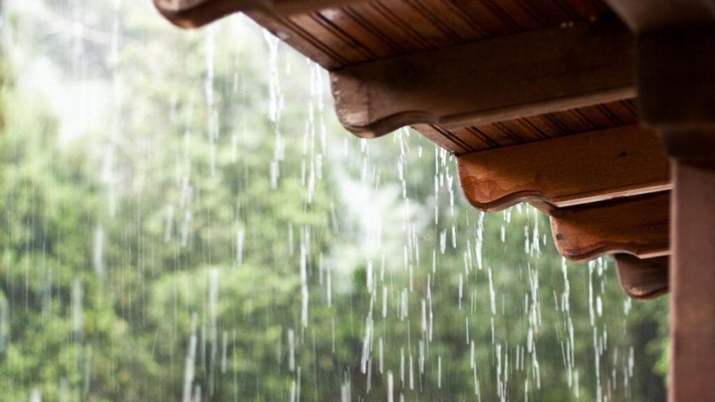 Heavy rain pouring from the edge of a roof