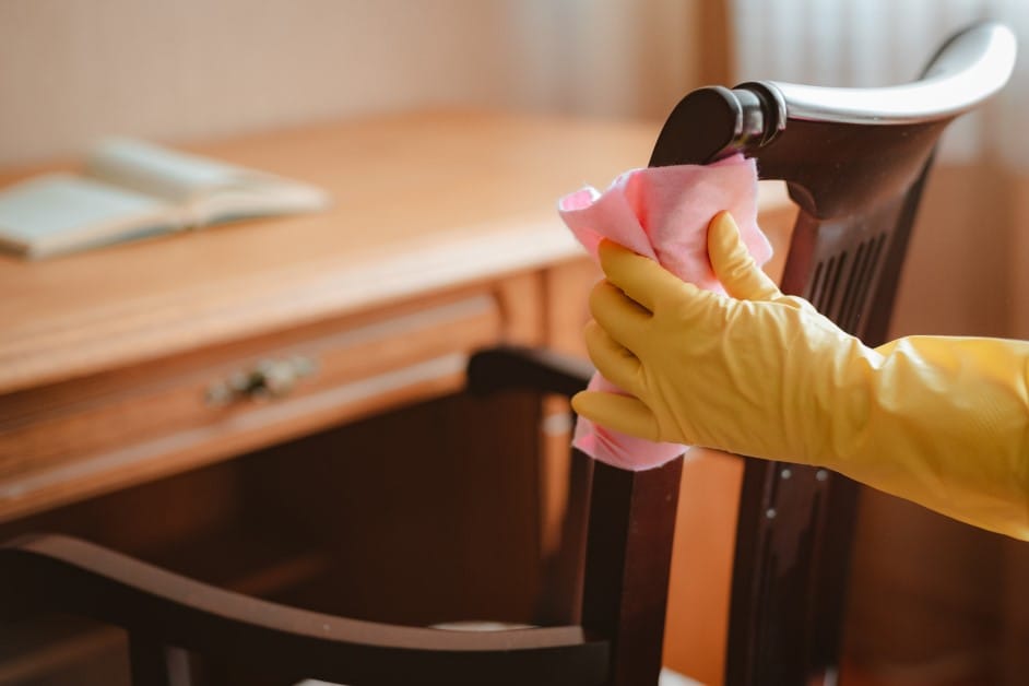 dusting wooden chair with microfiber towel