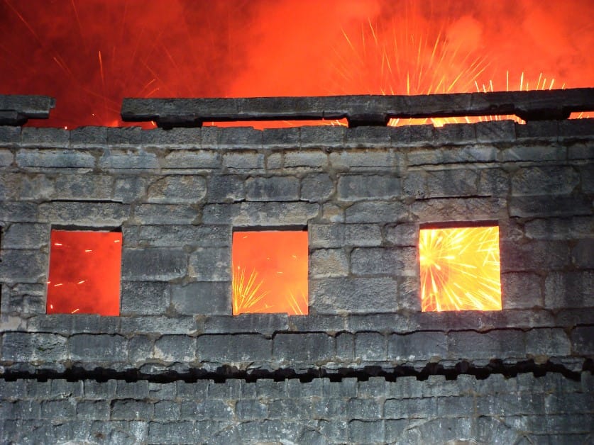 fire resistant concrete wall with three windows against a backdrop of fireworks exploding overhead.