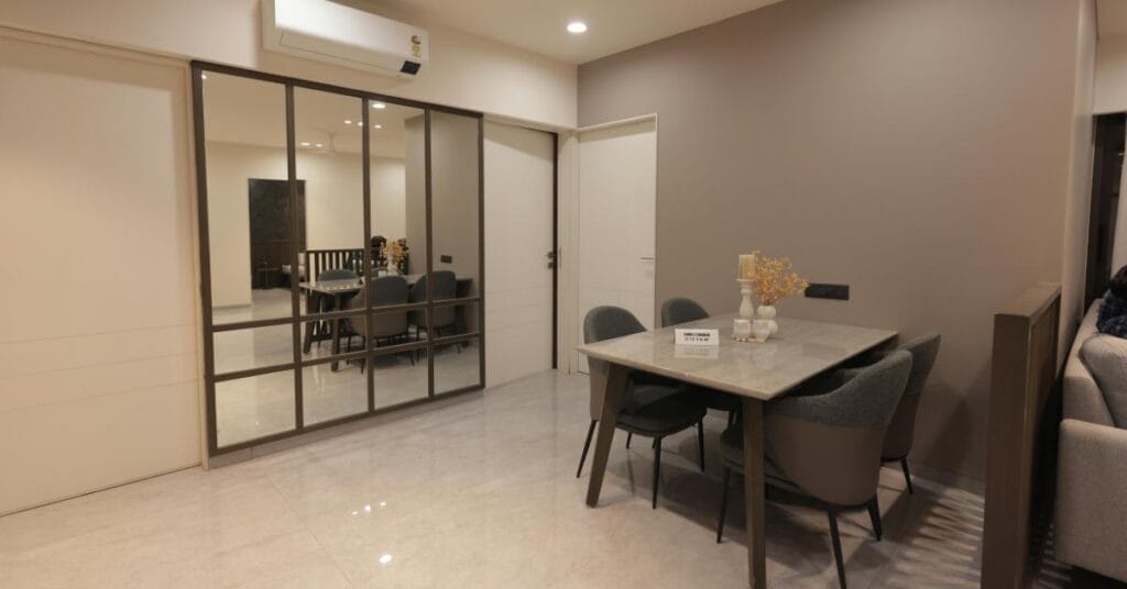 Small dining area uses a large, framed mirror to reflect light and visually double the room's size.