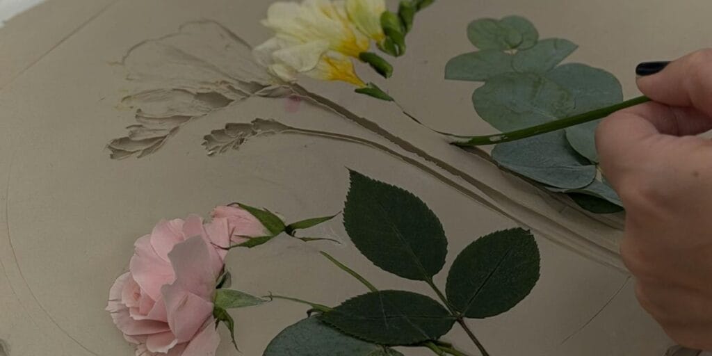 Arranging a Valentines flower pink rose and yellow freesia on a flat surface to be pressed and preserved.