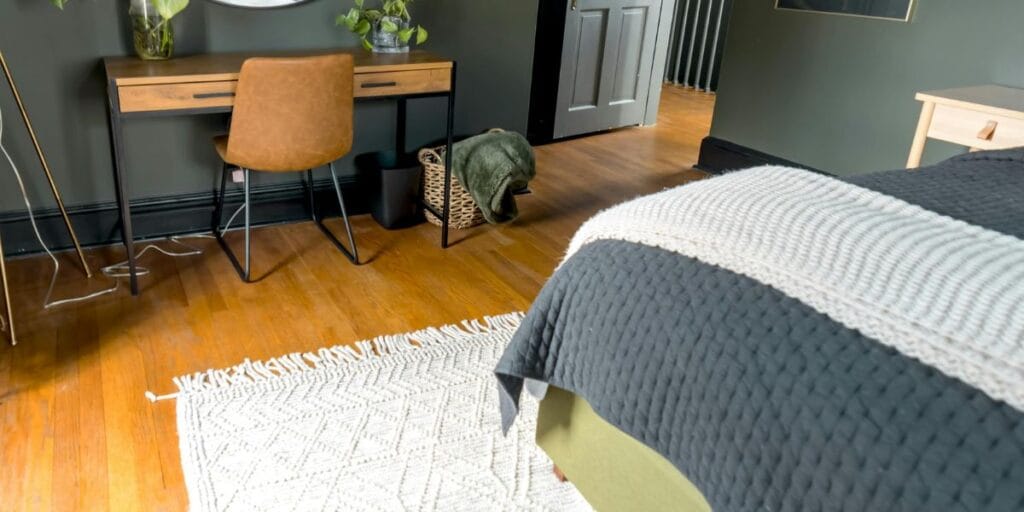 A textured white area rug under a bed
