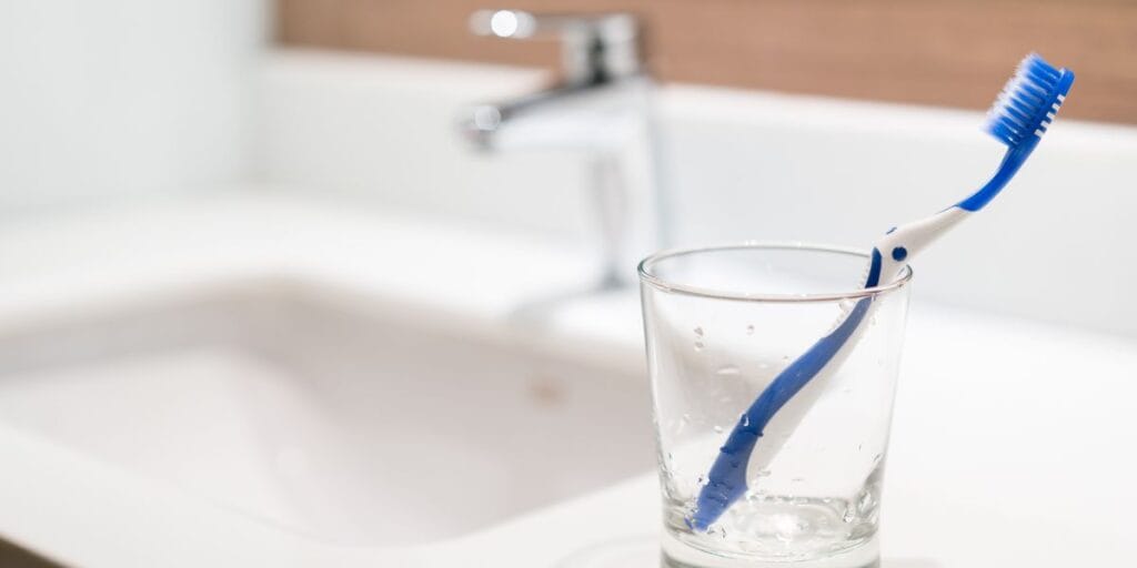 A toothbrush in a glass holder