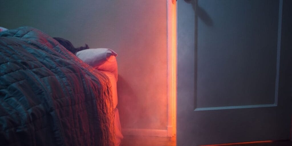 A bed headboard placed directly next to an open door