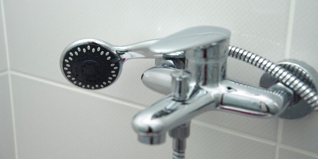 A chrome bathroom shower head, an everyday item prone to hidden mineral and mold buildup.