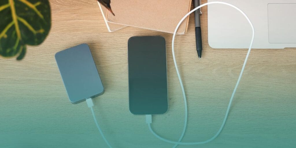 Smartphone charging with a power bank during a power outage caused by heavy rain.