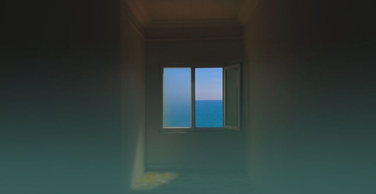 A small window in a dimly lit, narrow space illustrating how limited natural light can make a room look smaller than it is.