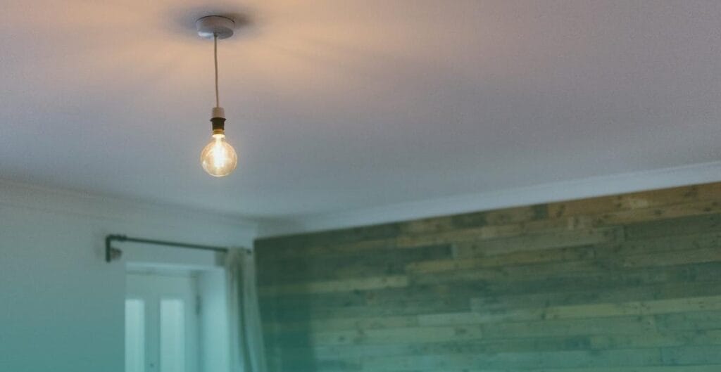 A single bare light bulb hanging from a ceiling